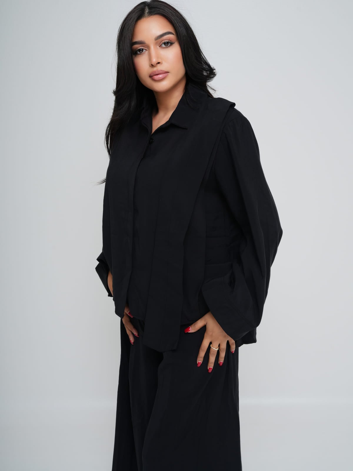 Black longline shirt worn over matching wide-leg trousers in lightweight summer fabric