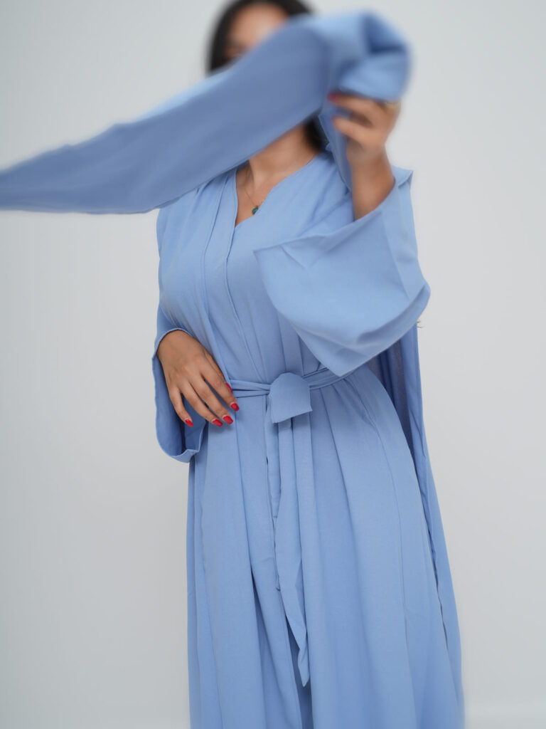 Light blue open abaya with a tie waist, worn over matching wide-leg pants